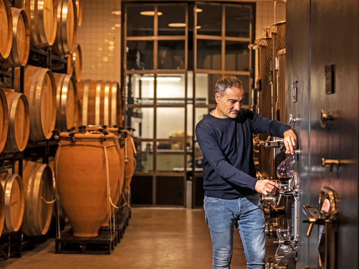 Arizcuren sirve uno de los vinos de la añada 2022, directamente del depósito de hormigón
